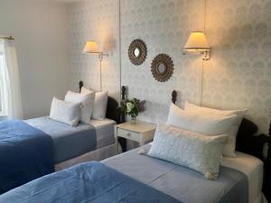 a hotel room with two beds with blue sheets at Barrington Inn Barn in New Shoreham