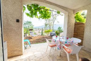 a table and chairs on a patio with a view at Rez-de-villa climatisé, jacuzzi et piscine in La Roquette-sur-Siagne