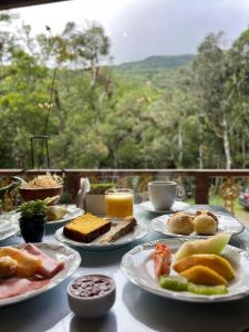a table with plates of food on it with a view at Estalagem Spiller in Monte Verde