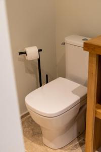 een wit toilet in een badkamer met een rol toiletpapier bij Vie Ventoux in Malaucène