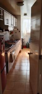 a kitchen with white cabinets and a tile floor at Departamento en Barrio Exclusivo - La Serena in La Serena