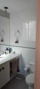 a white bathroom with a toilet and a sink at Departamento en Barrio Exclusivo - La Serena in La Serena