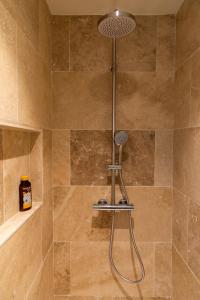 een douche met een douchekop in de badkamer bij Vie Ventoux in Malaucène