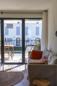 ein Wohnzimmer mit einem Sofa und Blick auf einen Innenhof in der Unterkunft Vie Ventoux - Studio in Malaucène