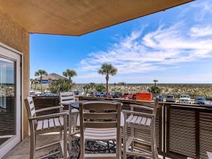 balcón con sillas y vistas a un aparcamiento en Wonderful Ocean Views, Heated Pool Access, Steps to Beach! By Southern Belle Tybee, en Tybee Island