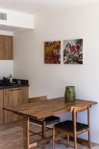 a wooden table in a kitchen with two paintings on the wall at Vie Ventoux in Malaucène