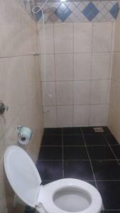 a bathroom with a toilet and a tiled floor at casa próximo a John boy dunlop in Campinas