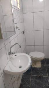 a white bathroom with a toilet and a sink at casa próximo a John boy dunlop in Campinas