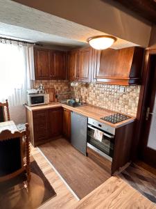 a kitchen with wooden cabinets and a stove top oven at Villa 99 in Popova Shapka