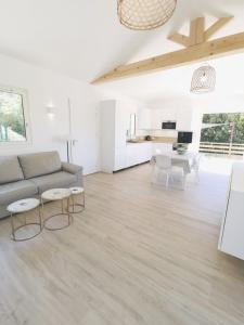Sala de estar blanca con sofá y mesa en Maisonnette avec 2 chambres climatisée en face de la plage de Gigaro, en La Croix-Valmer