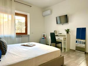 a bedroom with a bed and a desk and a television at center SUITE sorrento baby 2 in Sorrento