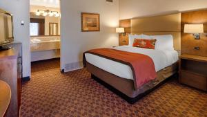 Habitación de hotel con cama grande y baño. en Best Western Outlaw Inn en Rock Springs