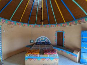 DhordoにあるWhite Rann Homestayの屋根付きの部屋にベッド1台が備わるベッドルーム1室があります。