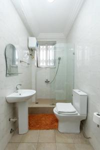 uma casa de banho com um WC, um lavatório e um chuveiro em Washington Apartments - just 25mins drive from the Airport em Kwashieman