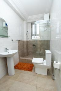 uma casa de banho com um WC, um lavatório e um chuveiro em Washington Apartments - just 25mins drive from the Airport em Kwashieman