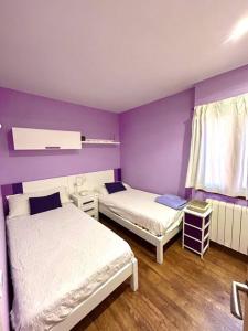 duas camas num quarto com paredes roxas em Casa Begur vistas espectaculares em Begur