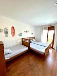 2 camas num quarto com pisos em madeira e uma janela em Casa Begur vistas espectaculares em Begur