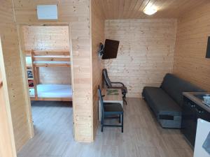Habitación pequeña con sofá y litera en Apartamenty Domki Pokoje WeMa Wicie, en Wicie