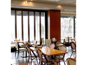 - une salle à manger avec des tables, des chaises et des fenêtres dans l'établissement Hotel Crystal Palace - Vacation STAY 61208v, à Hitachinaka