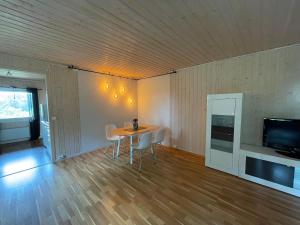 a dining room with a table and chairs and a television at Sentral og romslig leilighet nært Senja in Finnsnes
