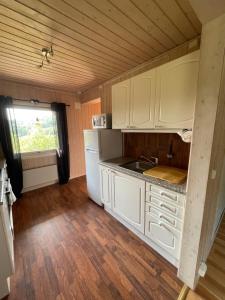 una pequeña cocina con armarios blancos y una ventana en Sentral og romslig leilighet nært Senja, en Finnsnes