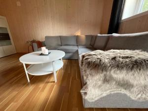 a living room with a couch and a table at Sentral og romslig leilighet nært Senja in Finnsnes