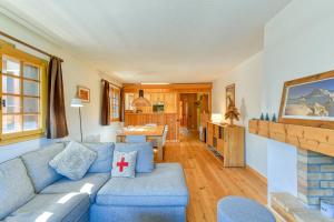 a living room with a blue couch and a fireplace at Ski nest - Pool - Mont Blanc view in Saint-Gervais-les-Bains