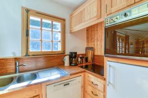 a kitchen with wooden cabinets and a sink at Ski nest - Pool - Mont Blanc view in Saint-Gervais-les-Bains