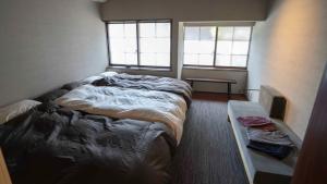 a small bedroom with a bed and two windows at MAGONI - Vacation STAY 66671v in Kaga