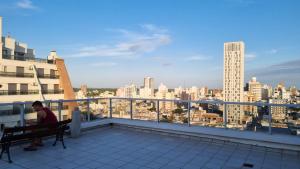 a man sitting on a bench on top of a building at Home in Río Cuarto