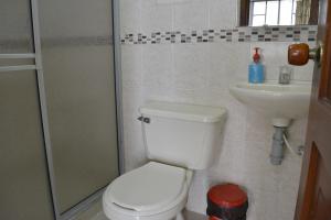 a bathroom with a toilet and a sink at Hotel La Mansión del Sol in Tuluá