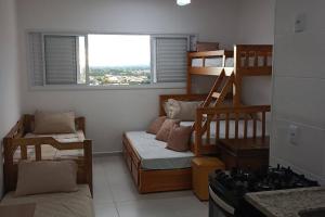 a small room with a bunk bed and a kitchen at Apartamento em Cachoeira Pta in Cachoeira Paulista