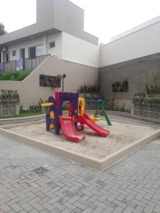 a playground with a slide in a courtyard at Apartamento em Cachoeira Pta in Cachoeira Paulista
