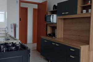 a kitchen with a counter top with a microwave at Apartamento em Cachoeira Pta in Cachoeira Paulista