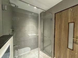 un bagno con doccia con porta in vetro di Hotel Devdeep Porvorim ad Alto Porvorim Altre 32 foto