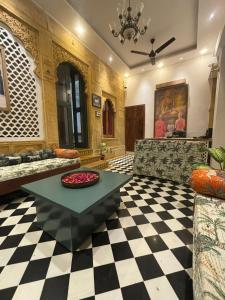 een woonkamer met een bank en een tafel bij Kiran Apartment in Jaisalmer