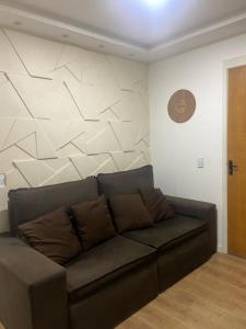 een bank in een woonkamer met een muur bij Apartamento 2 Quartos c/ Vaga de Estacionamento in Serra