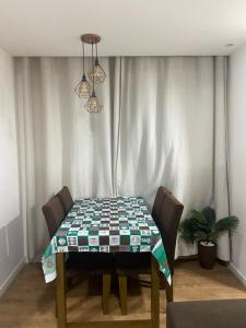 een eettafel met een tafelkleed erop bij Apartamento 2 Quartos c/ Vaga de Estacionamento in Serra