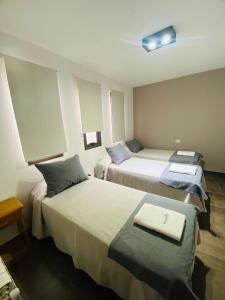 una habitación de hotel con 2 camas y una luz en el techo en Ranqueles en Villa Carlos Paz