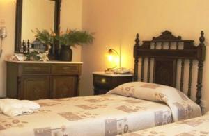 a bedroom with a bed with a dresser and a mirror at Aegeon Hotel in Karlovasi