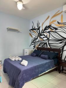 a bedroom with a bed with a painting on the wall at Aconchego da Vila in Mangaratiba