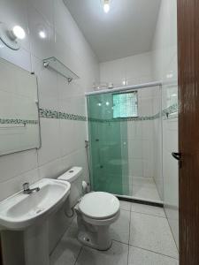 a bathroom with a shower and a toilet and a sink at Aconchego da Vila in Mangaratiba