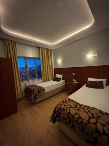a hotel room with two beds and a window at Ankara Santral Otel in Altındağ