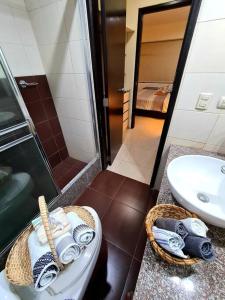 a bathroom with a sink and a toilet and a shower at Ecusuites Ejecutiva Torre Sol Aeropuerto IX in Guayaquil