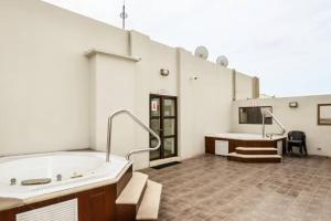 uma ampla casa de banho com uma banheira e uma secretária em Ecusuites Ejecutiva Torre Sol Aeropuerto IX em Guayaquil