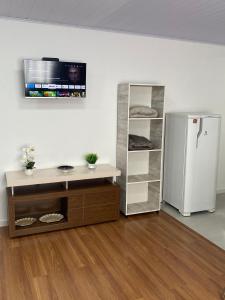 Zimmer mit einem weißen Kühlschrank und einem Regal in der Unterkunft RCM Vilas - Studio 103 Deluxe in Joinville