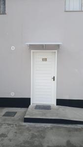 Una puerta de garaje blanca con el número. en RCM Vilas - Studio 103 Deluxe, en Joinville