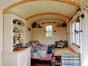 Habitación pequeña con cama y mesa en Cefnmachllys Shepherds Huts en Brecon