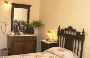 a bedroom with a bed and a mirror and a phone at Aegeon Hotel in Karlovasi
