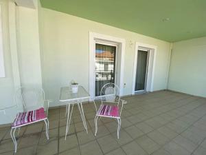 un patio con 2 sillas, una mesa y una mesa en Groovy Apartment en Tripolis